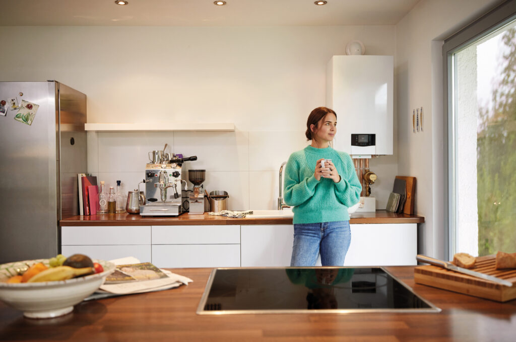 Young white female standing in front of newly installed boiler in Wrington